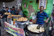 India, New Delhi, A cook making kachori at a street stall in the old city of Delhi.