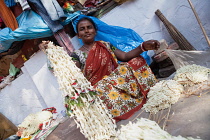 India, West Bengal, Kolkata, A vendor at Malik Ghat flower market.