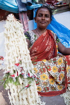 India, West Bengal, Kolkata, A vendor at Malik Ghat flower market.