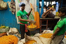 India, West Bengal, Kolkata, Vendor at Malik Ghat Flower Market.