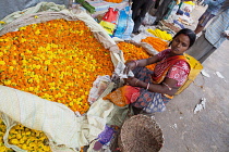 India, West Bengal, Kolkata, Vendor at Malik Ghat flower market.