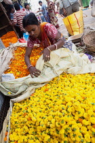 India, West Bengal, Kolkata, Vendor at Malik Ghat flower market.