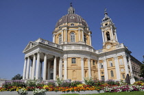 Italy, Piedmont, Turin, Basilica Superga with flowering garden in foreground.