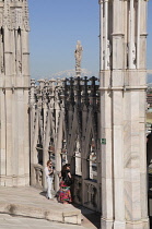 Italy, Lombardy, Milan, taking in the view, Duomo rooftop with Alps in the distance.