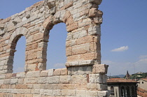 Italy, Veneto, Verona, Arena arches with city skyline.