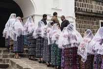 Guatemala, Solola Department, San Pedro la Laguna, A line of women wait on the steps of the Church of San Pedro for a religious procession to arrive.