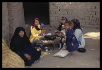 Egypt, Nile Valley, Family sat in courtyard eating food.