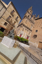 Spain, Castile and Leon, Salamanca, the monument to Spanish music theorist and organist Francisco de Salinas with La Clerecía Church and Casa de las Conchas behind.