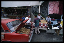 Uzbekistan, Tashkent, Chorsu  unloading bread from boot of Lada car