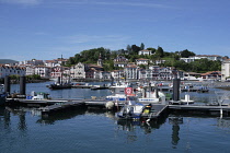 France, Pays Basque, St Jean de Luz harbour looking towards the neighbouring town of Cibourne. Pleasure and fishing boats moored up.