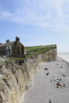 England, East Sussex, Birling Gap, View passed costguard cottages showing chalk cliffs and pebble beach.