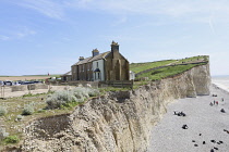 England, East Sussex, Birling Gap, View passed costguard cottages showing chalk cliffs and pebble beach.