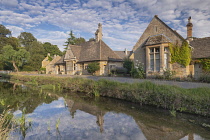 England, Gloucestershire, Cotswolds, Lower Slaughter, River Eye and typical Cotswold streetscape in evening light.