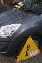 Law & Order, Traffic Control, Parking, Front wheel of car clamped by DVLA with ticket stuck to windscreen,