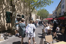 France, Provence-Alpes-Cote d'Azur, Antibes, Narrow street in the Old town with eople sat outside restaurants.