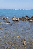 France, Provence-Alpes-Cote d'Azur, Antibes, Rock balanced stacks in shallow water.