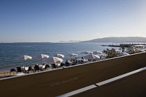 France, Provence-Alpes-Cote d'Azur, Antibes, Juan-les-Pins, Beach front restaurant and bars with parasols on the sandy beach.