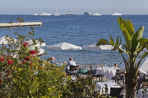 France, Provence-Alpes-Cote d'Azur, Antibes, Juan-les-Pins, Beach front restaurant and bars with parasols on the sandy beach.