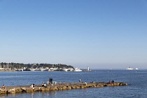 France, Provence-Alpes-Cote d'Azur, Antibes, Juan-les-Pins, People fishing from jetty.