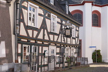 Germany, Hesse, Idstein, Half timbered Gasthaus Zum Schwanen with the Protestant Unionskirche or Union Church dating from 1350  in the background.