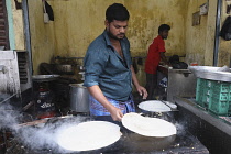 India, Tamil Nadu, Chennai, Man cooking dosa in the market.