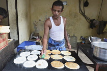 India, Tamil Nadu, Chennai, Man cooking dosa in the market.