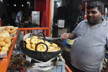 India, Tamil Nadu, Hyderabad, Man cooking vada pav in the market.