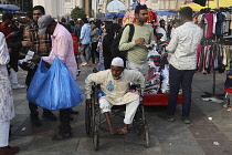 India, Tamil Nadu, Hyderabad, Beggar in wheelchair at the market.