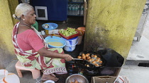 India, Tamil Nadu, Tirupathi, Woman cooking vada in the market.