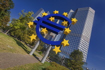 Germany, Hesse, Frankfurt, Euro-Skulptur, the 14 metre tall electronic sign by Ottmar Horl that shows a Euro currency sign with twelve stars around it, weighing 50 tonnes and located outside the Europ...